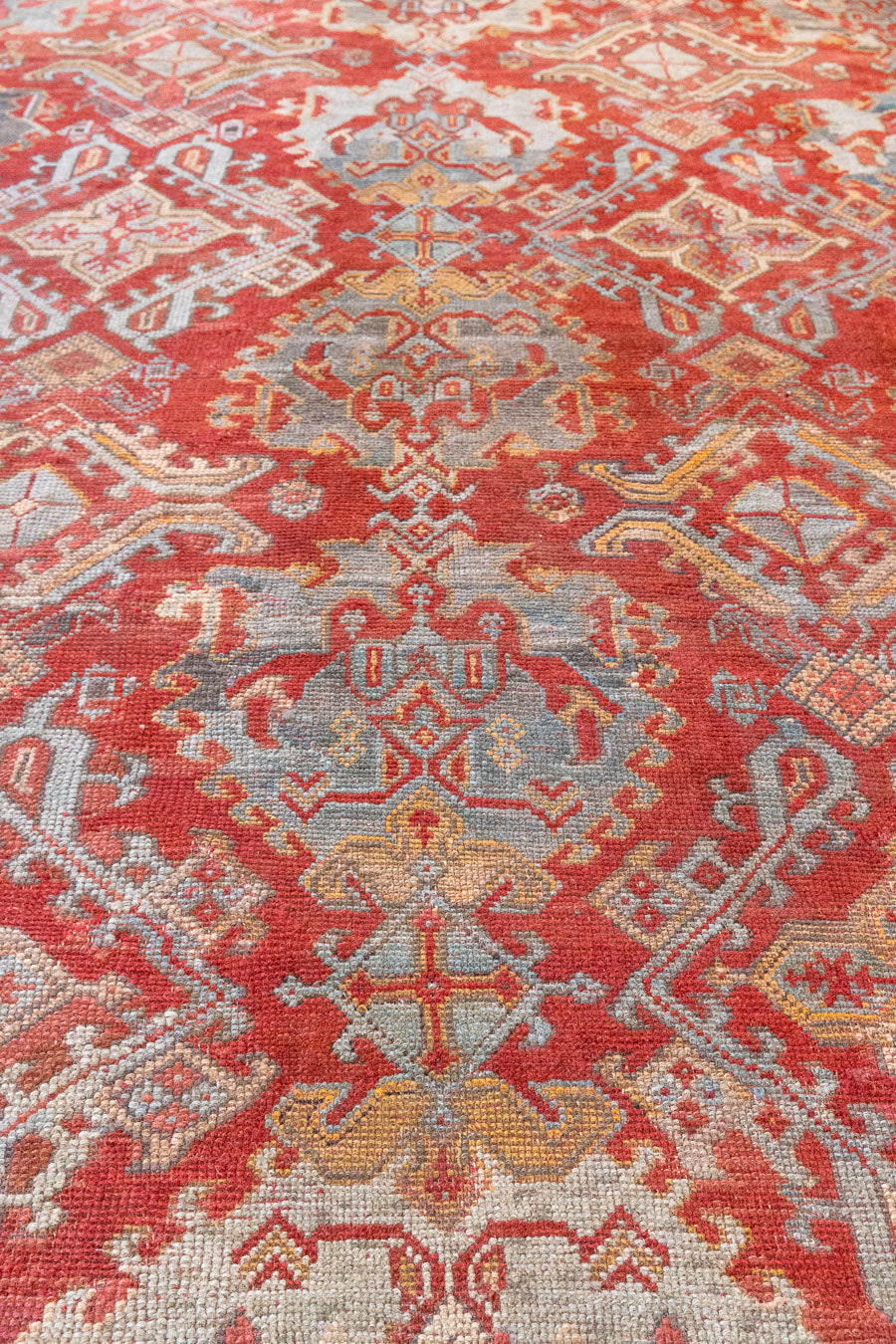 Early 20th-century antique Turkish carpet in red, blue and ivory, a large handwoven Oushak rug by Ourika London