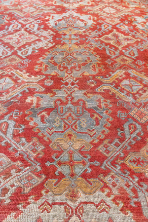 Early 20th-century antique Turkish carpet in red, blue and ivory, a large handwoven Oushak rug by Ourika London