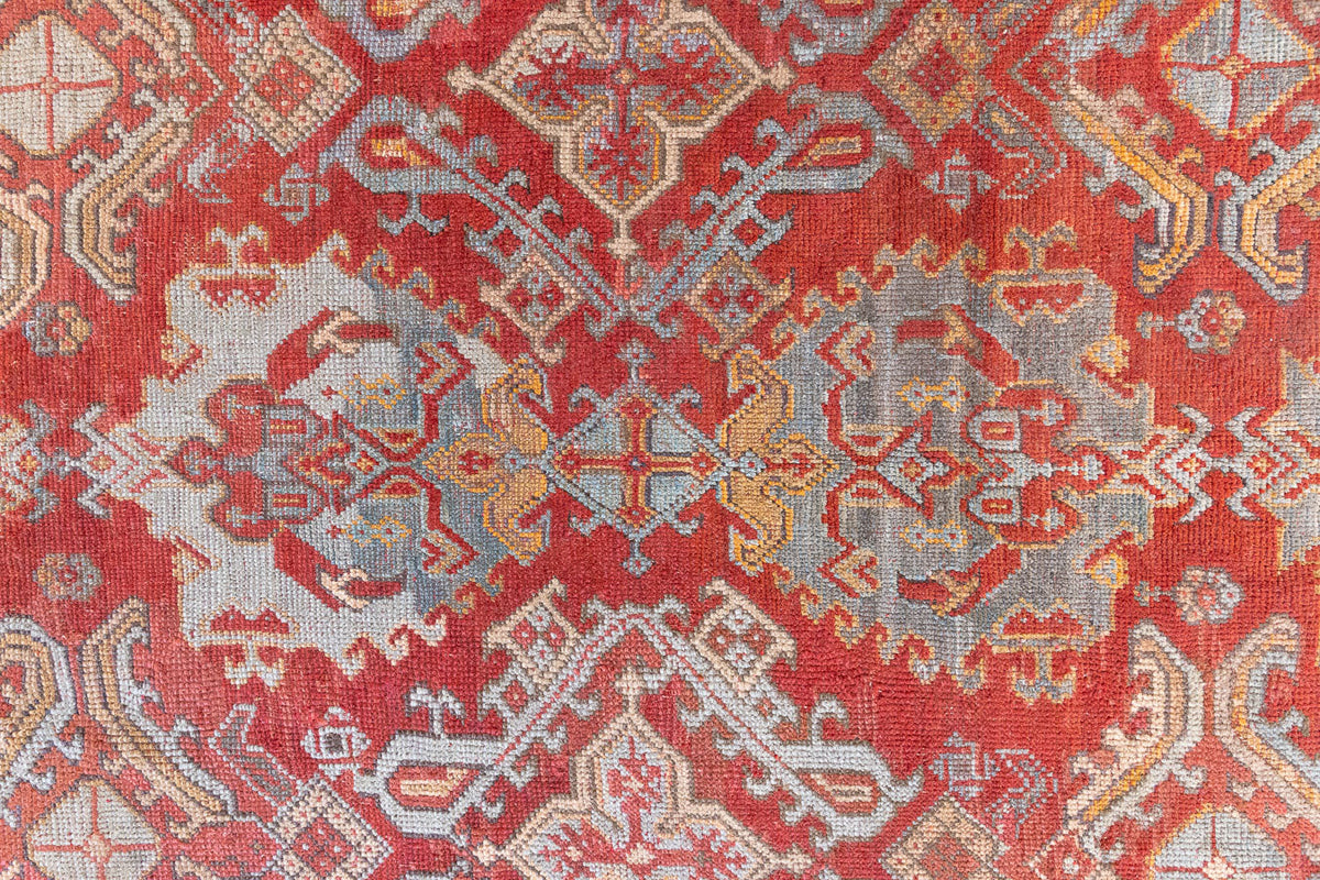 Early 20th-century antique Turkish carpet in red, blue and ivory, a large handwoven Oushak rug by Ourika London