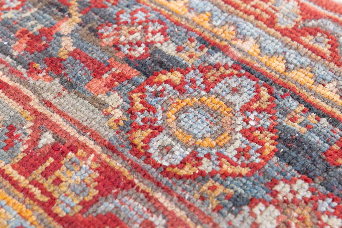 An antique Turkish Oushak rug in rich red with deep blue and ivory