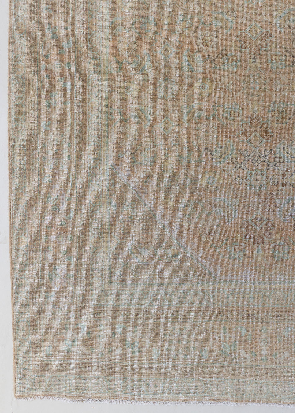 An antique Persian Mahal rug in pinky taupe with an all-over floral design in blue