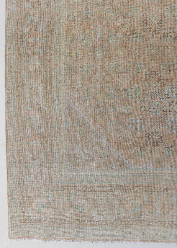 An antique Persian Mahal rug in pinky taupe with an all-over floral design in blue