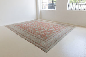 This is an antique Persian Kashan handwoven carpet in blue red and ivory tones. This hand woven wool rug features a all over floral design.