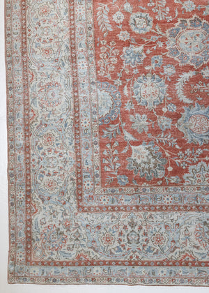 This is an antique Persian Kashan handwoven carpet in blue red and ivory tones. This hand woven wool antique rug features a all over floral design.