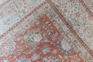 This is an antique Persian Kashan handwoven carpet in blue red and ivory tones. This vintage hand woven wool rug features a all over floral design.