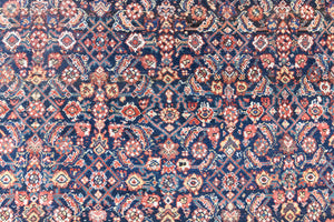 Vita is a beautiful Mahal rug featuring a navy blue field and a decorative all over Herati floral design, framed by a soft rust boarder. Mahal carpets are some of the most desirable Persian village rugs, often sought after by interior designers and collectors.