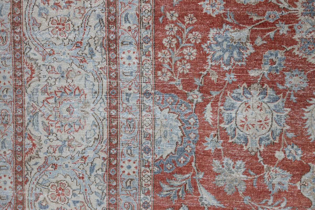 This is an antique Persian Kashan handwoven carpet in blue red and ivory tones. This vintage handmade wool rug features an all over floral design.