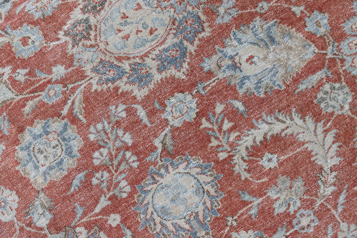 This is an antique Persian Kashan handwoven carpet in blue red and ivory tones. This vintage hand woven wool rug features a all over floral design.