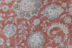 This is an antique Persian Kashan handwoven carpet in blue red and ivory tones. This vintage hand woven wool rug features a all over floral design.