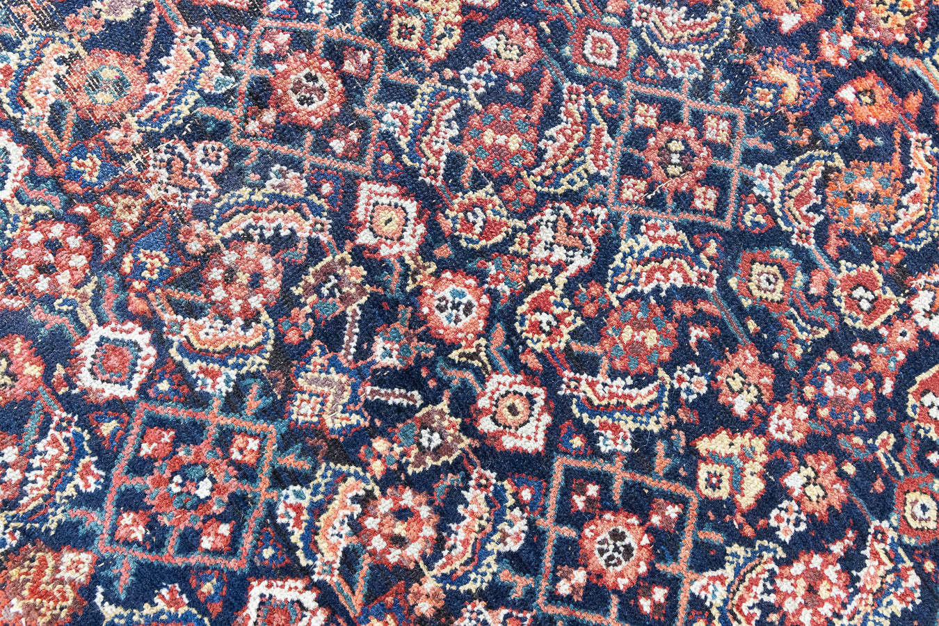 Vita is a beautiful Mahal rug featuring a navy blue field and a decorative all over Herati floral design, framed by a soft rust boarder. Mahal carpets are some of the most desirable Persian village rugs, often sought after by interior designers and collectors.