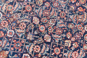 Vita is a beautiful Mahal rug featuring a navy blue field and a decorative all over Herati floral design, framed by a soft rust boarder. Mahal carpets are some of the most desirable Persian village rugs, often sought after by interior designers and collectors.