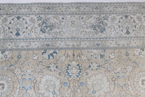 This is an antique Persian Tabriz handwoven carpet in muted blue with ivory tones. This vintage hand woven wool rug features a all over floral design.