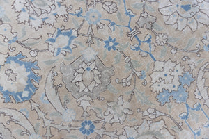 This is an antique Persian Tabriz handwoven carpet in muted blue with ivory tones. This vintage hand woven wool rug features a all over floral design.