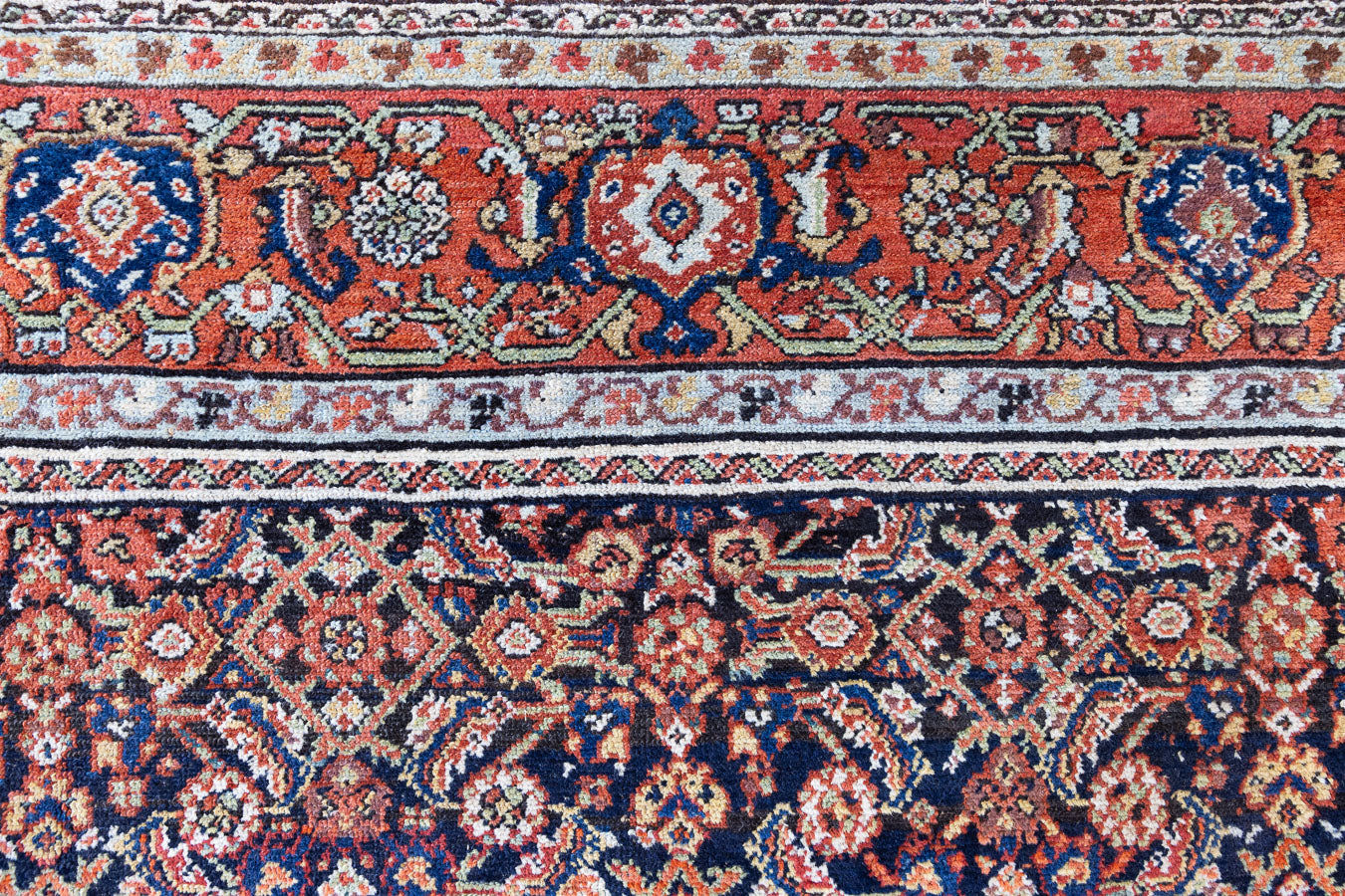 Vita is a beautiful Mahal rug featuring a navy blue field and a decorative all over Herati floral design, framed by a soft rust boarder. Mahal carpets are some of the most desirable Persian village rugs, often sought after by interior designers and collectors.
