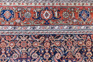 Vita is a beautiful Mahal rug featuring a navy blue field and a decorative all over Herati floral design, framed by a soft rust boarder. Mahal carpets are some of the most desirable Persian village rugs, often sought after by interior designers and collectors.
