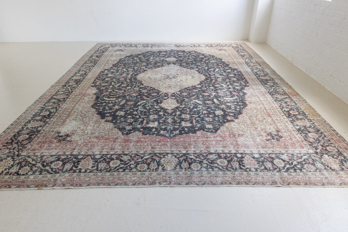 This is an large antique Persian Mahal handwoven carpet in a deep navy blue and a pinky red with ivory tones. This vintage hand woven wool rug features a all over floral design.