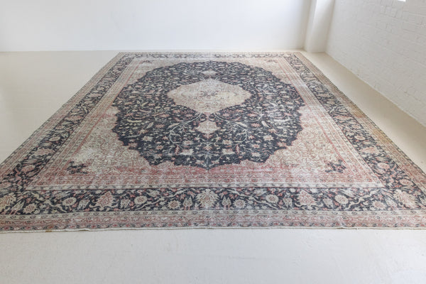 This is an large antique Persian Mahal handwoven carpet in a deep navy blue and a pinky red with ivory tones. This vintage hand woven wool rug features a all over floral design.