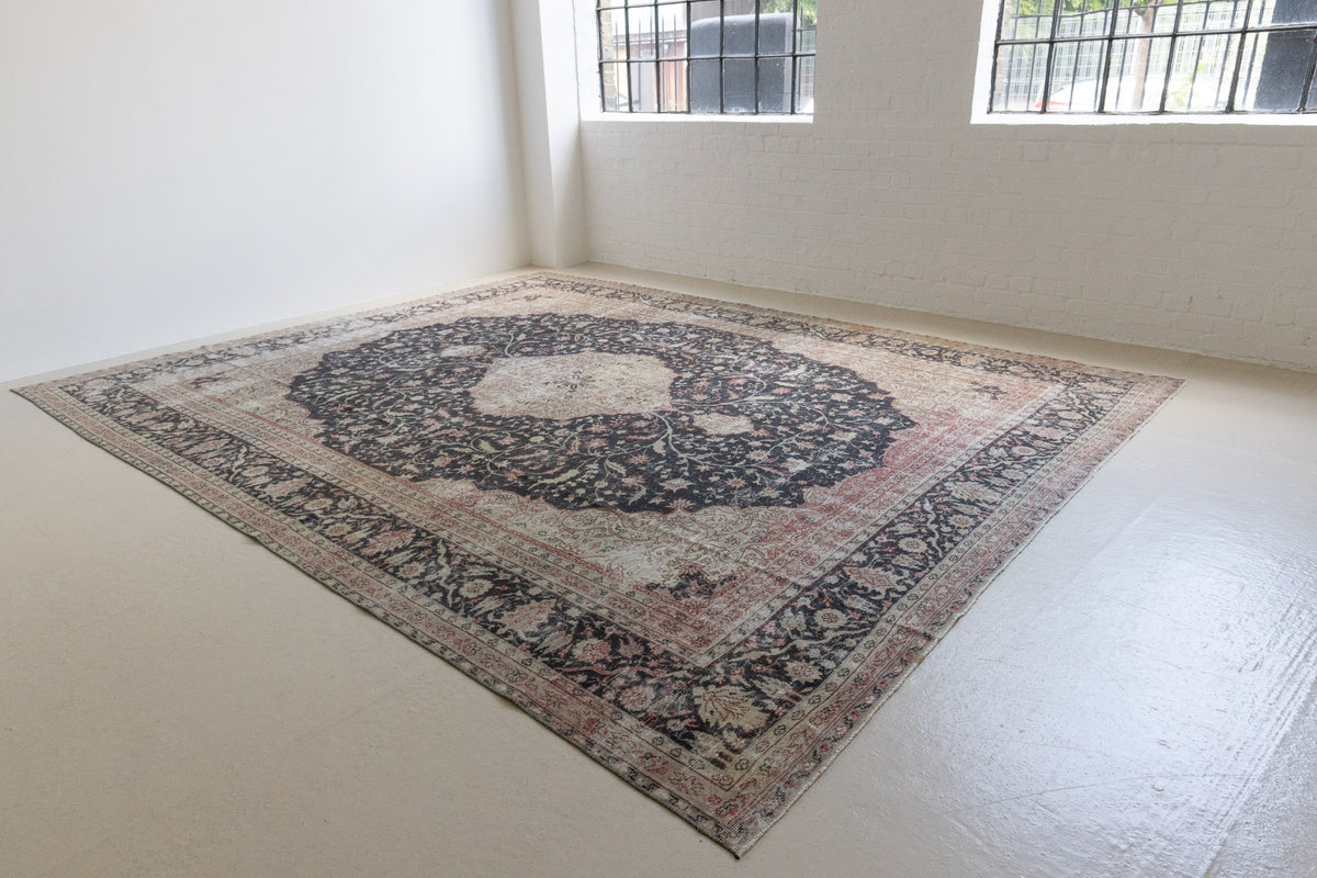 This is an large antique Persian Mahal handwoven carpet in a deep navy blue and a pinky red with ivory tones. This vintage hand woven wool rug features a all over floral design.