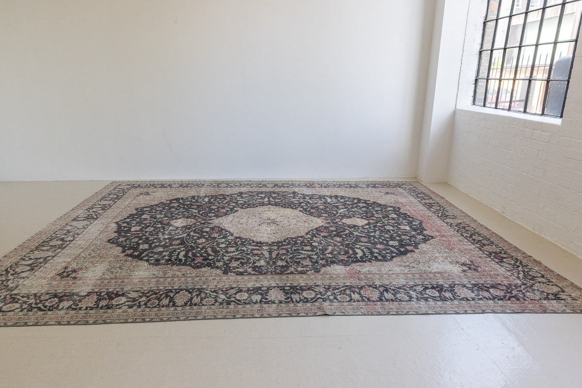 This is an large antique Persian Mahal handwoven carpet in a deep navy blue and a pinky red with ivory tones. This vintage hand woven wool rug features a all over floral design.
