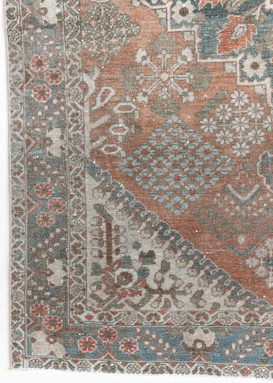 An antique Persian Bakhtiyari rug with a bold medallion in blue, green and terracotta. This handwoven Persian carpet boasts a  pretty floral border.
