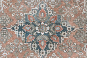 An antique Persian Bakhtiyari rug with a bold medallion in blue, green and terracotta. This handwoven Persian carpet has a  pretty floral border.