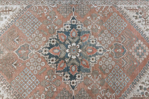 An antique Persian Bakhtiyari rug with a bold medallion in blue, green and terracotta. This handwoven Persian carpet boasts a  pretty floral border.