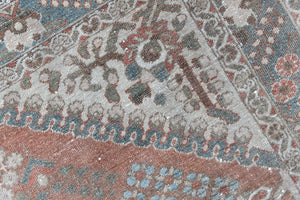 An antique Persian Bakhtiyari rug with a bold medallion in blue, green and terracotta. This handwoven Persian carpet has a  pretty floral pattern.