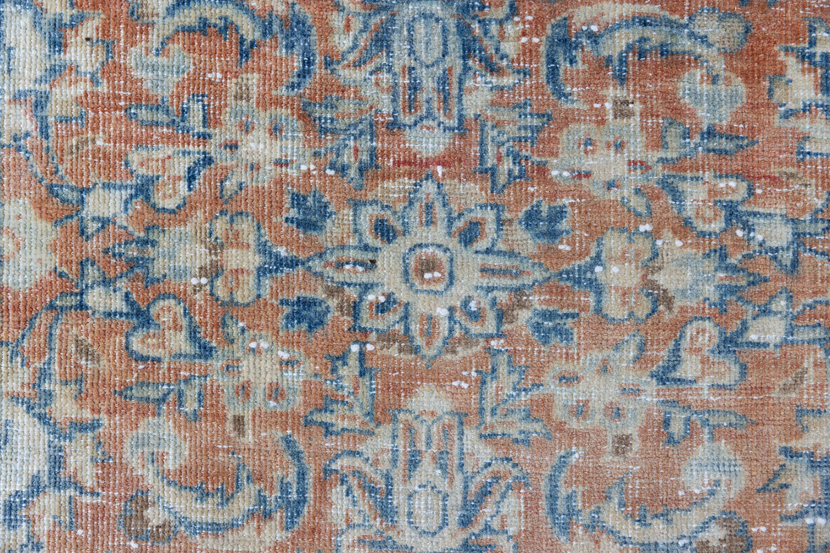 This is an large antique Persian Mahal runner handwoven carpet in a rusty orange red  and muted blue with ivory tones. This vintage hand woven wool rug features a all over floral design.