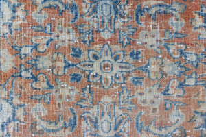This is an large antique Persian Mahal runner handwoven carpet in a rusty orange red  and muted blue with ivory tones. This vintage hand woven wool rug features a all over floral design.