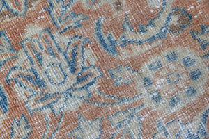 This is an large antique Persian Mahal runner handwoven carpet in a rusty orange red  and muted blue with ivory tones. This vintage hand woven wool rug features a all over floral design.