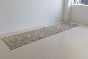 This is an large antique Persian Mahal runner handwoven carpet in a rusty orange red  and muted blue with ivory tones. This vintage hand woven wool rug features a all over floral design.