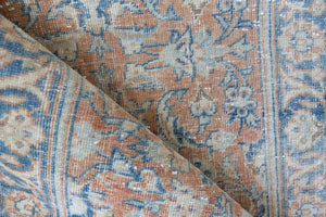 This is an large antique Persian Mahal runner handwoven carpet in a rusty orange red  and muted blue with ivory tones. This vintage hand woven wool rug features a all over floral design.