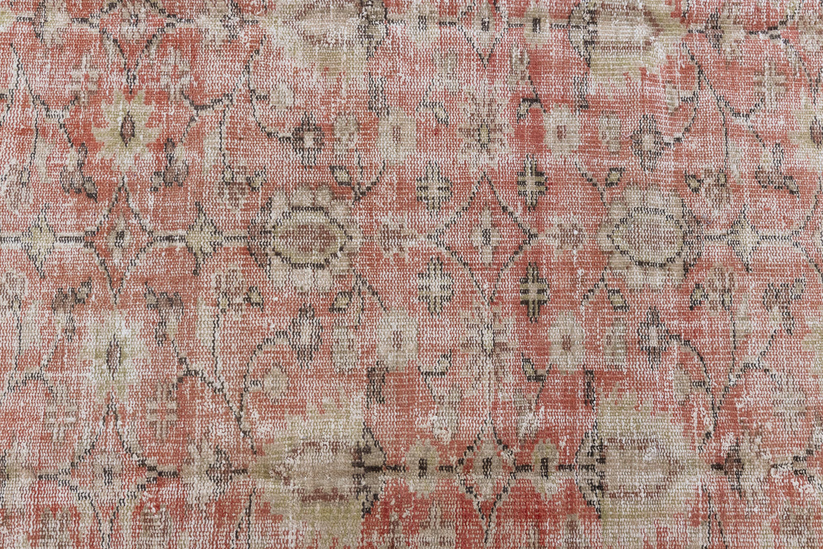 This is an large antique Turkish handwoven carpet in a rusty orange red  and muted blue with ivory tones. This vintage hand woven wool rug features a all over floral design.