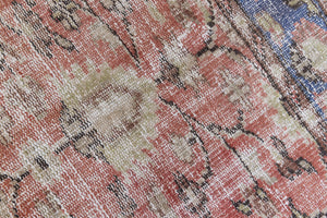 This is an large antique Turkish handwoven carpet in a rusty orange red  and muted blue with ivory tones. This vintage hand woven wool rug features a all over floral design.