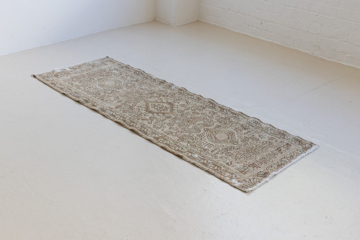 A vintage Persian Heriz runner. Heriz rugs are some of the most sought after Persian carpets and this one features a classic Karaja design in soft taupe and chocolate brown tones with sage green accents.