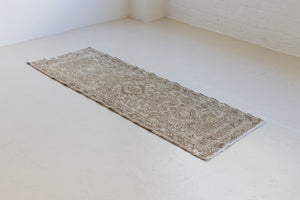 A vintage Persian Heriz runner. Heriz rugs are some of the most sought after Persian carpets and this one features a classic Karaja design in soft taupe and chocolate brown tones with sage green accents.