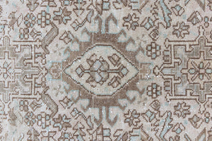 Close up of a vintage Persian Heriz runner. Heriz rugs are some of the most sought after Persian carpets and this one features a classic Karaja design in soft taupe and chocolate brown tones with sage green accents.