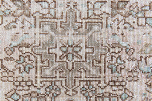 Close up of a vintage Persian Heriz runner. Heriz rugs are some of the most sought after Persian carpets and this one features a classic Karaja design in soft taupe and chocolate brown tones with sage green accents.