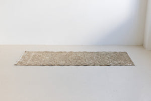 A vintage Persian Heriz runner. Heriz rugs are some of the most sought after Persian carpets and this one features a classic Karaja design in soft taupe and chocolate brown tones with sage green accents.