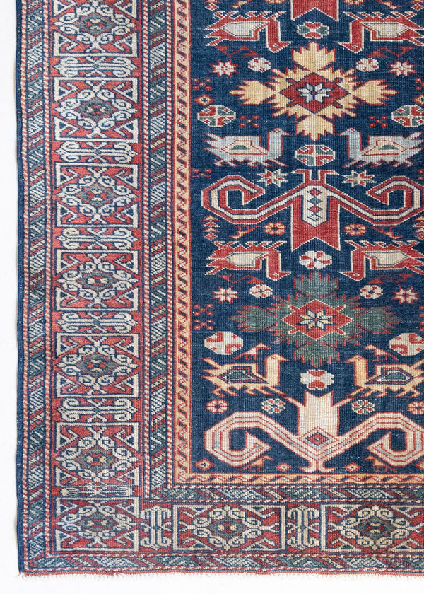 Beau is a beautiful antique Persian Caucasian runner in madder red and cream on a deep indigo ground, framed by a wide geometric border. Handwoven Caucasian carpets are prized for their bold geometric patterns and rich, saturated and jewel tones. 