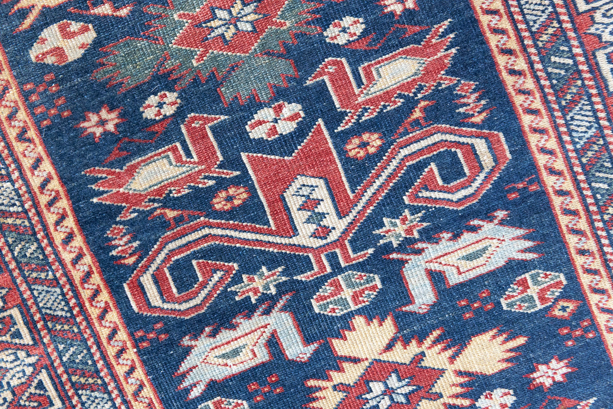 Beau is an antique Persian Caucasian runner in red and cream on a deep indigo ground. Handwoven Caucasian carpets are celebrated for their bold geometric patterns and rich, saturated and jewel tones. 