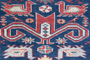 Beau is an antique Persian Caucasian runner in red and cream on a deep indigo ground, framed by a wide geometric border. Handwoven Caucasian carpets are prized for their bold geometric patterns and rich, saturated and jewel tones. 