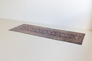 Beau is an antique Persian Caucasian runner in red and cream on a deep indigo ground, framed by a wide geometric border. Handwoven Caucasian carpets are prized for their bold geometric patterns and rich, saturated and jewel tones. 