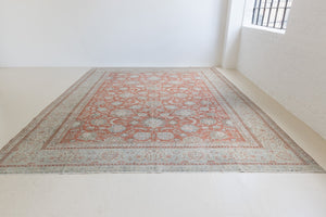 This is an antique Persian Kashan handwoven carpet in blue red and ivory tones. This hand woven wool antique rug features a all over floral design.