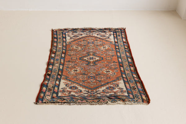 A vintage Persian Hamedan carpet in terracotta tones — this hand-knotted antique rug showcases a central medallion design.