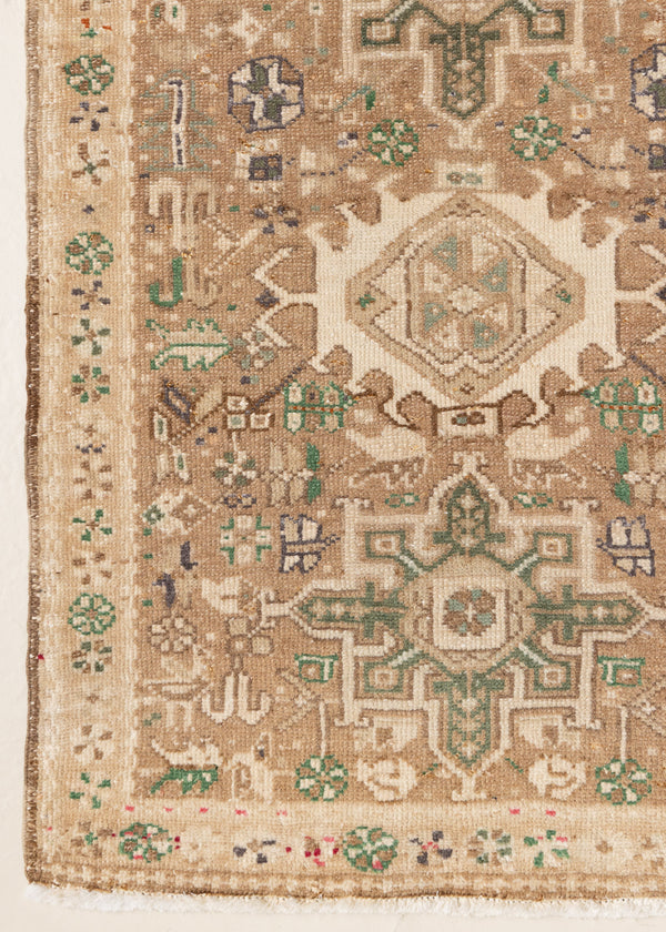 This is an antique Persian Heriz runner, a handmade rug in taupe, brown and green tones, featuring a Karaja design.