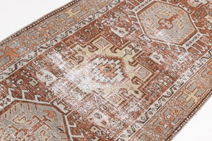 This is an antique Persian Heriz runner, a handmade rug in red and green tones, featuring a Karaja design.