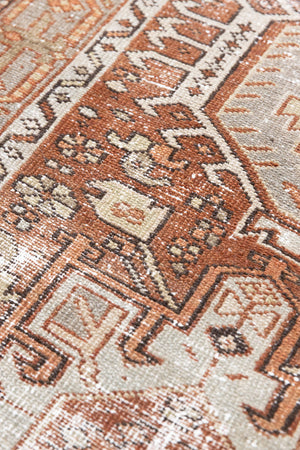 A vintage Persian Heriz runner in red and green tones — this hand-knotted antique carpet showcases a Karaja design.