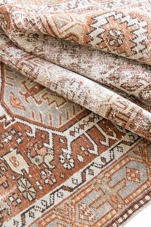 A vintage Persian Heriz runner in red and green tones — this hand-knotted antique carpet showcases a Karaja design.