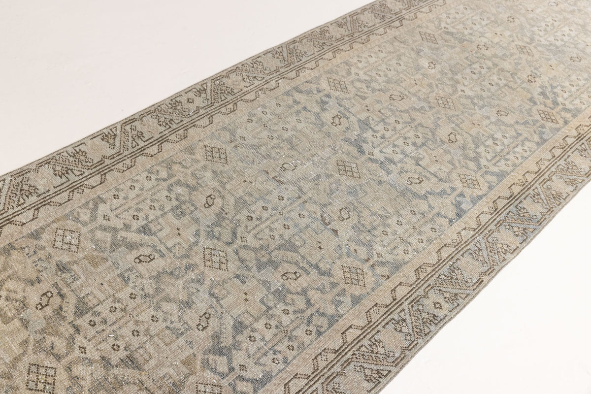 A vintage Persian Malayer runner in blue tones — this hand-knotted antique carpet showcases an all-over design.